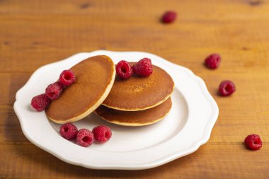 Ahududu ve ahşap zemin üzerine nane ile küçük gözleme