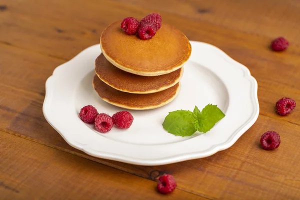 Ahududu ve ahşap zemin üzerine nane ile küçük gözleme