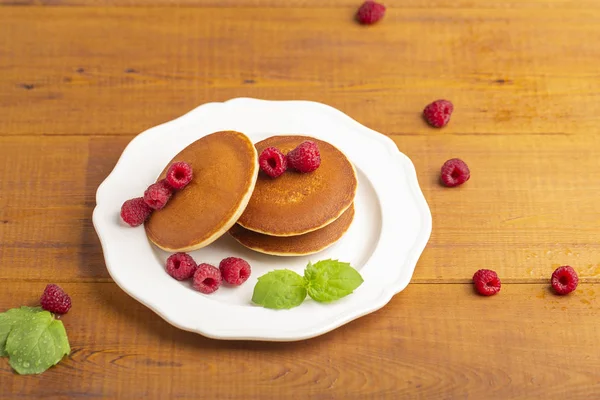 Ahududu ve ahşap zemin üzerine nane ile küçük gözleme