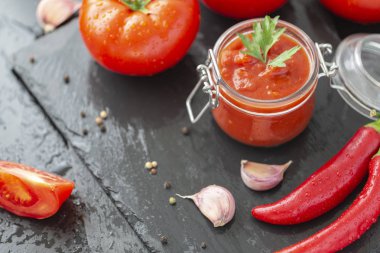 Adjika sos biber, sarımsak ve baharat siyah bir zemin üzerine yaptı. Sos. Gıda arka plan.