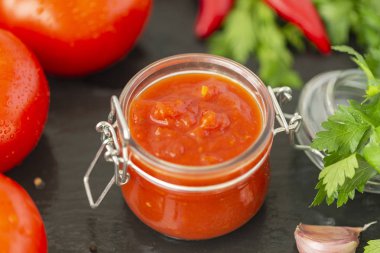 Adjika sos biber, sarımsak ve baharat siyah bir zemin üzerine yaptı. Sos. Gıda arka plan.