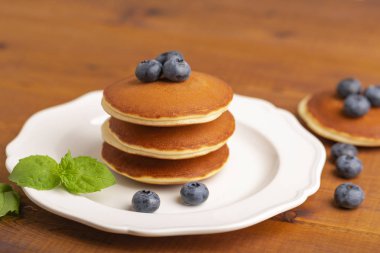 Taze yaban mersini ve beyaz tabakta nane ile lezzetli yakın çekim krep