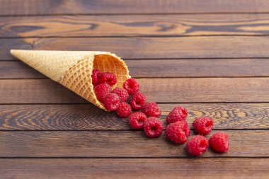 Dondurma veya taze ahududu ahşap arka plan üzerinde bir gözleme koni bir tatlı. Yakın çekim. Yaz, tazelik ve tatlı menüsü kavramı.