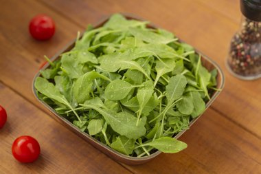 Ahşap arka plan üzerinde bir kase taze roka salatası