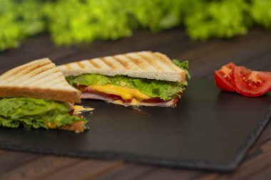 Lezzetli kahvaltı. İştah açıcı sandviç salam, peynir ve domates ile