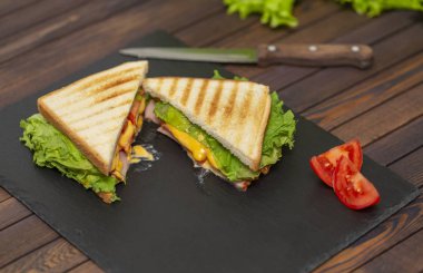 Lezzetli kahvaltı. İştah açıcı sandviç salam, peynir ve domates ile