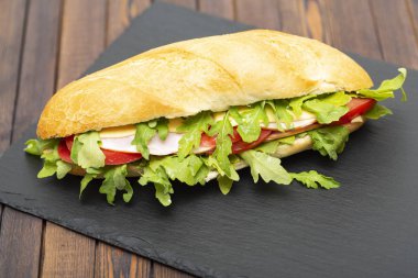 Jambon, domates, peynir ve roka marul ile baget sandviç. Lezzetli kahvaltı veya aperatif. Yakın çekim