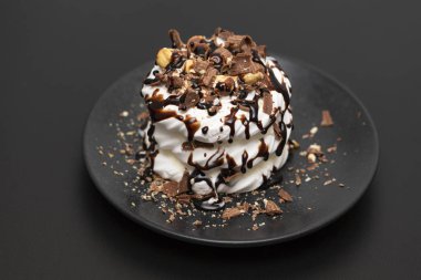 Beze tatlısı Pavlova pasta siyah arka plan üzerine çikolata şurubu ile