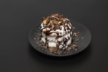 Beze tatlısı Pavlova pasta siyah arka plan üzerine çikolata şurubu ile
