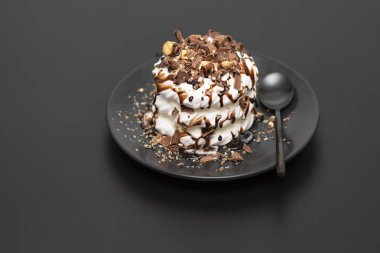 Beze tatlısı Pavlova pasta siyah arka plan üzerine çikolata şurubu ile