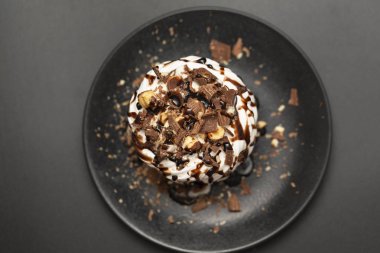 Beze tatlısı Pavlova pasta siyah arka plan üzerine çikolata şurubu ile