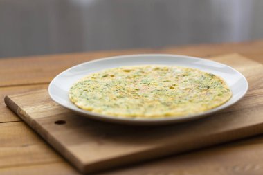 Otlar ile lezzetli omlet. Kahvaltıda omlet. Rendelenmiş peynir ve otlar ile omlet. Kahvaltı için yumurta çanak.