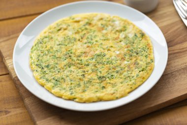 Otlar ile lezzetli omlet. Kahvaltıda omlet. Rendelenmiş peynir ve otlar ile omlet. Kahvaltı için yumurta çanak.