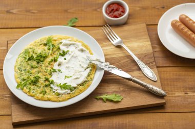 Otlar ile lezzetli omlet. Kahvaltıda omlet. Rendelenmiş peynir ve otlar ile omlet. Kahvaltı için yumurta çanak.