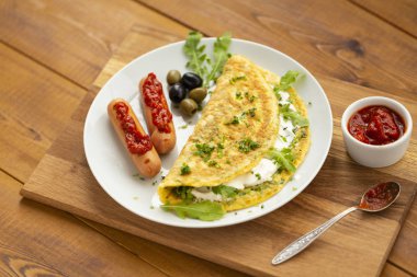 Otlu omlet, yumuşak peynir, ızgara sosis ve domates sosu. Nefis kahvaltı.