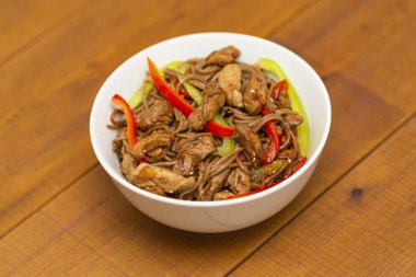 Tavuk, sebze ve susam ile Asya Erişte. Rustik ahşap arka plan. Yemek çubukları. Yakın çekim. Asya tarzı yemek