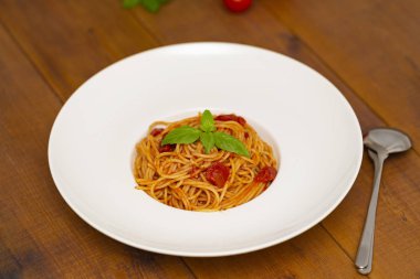 Tabak lezzetli İtalyan spagetti makarna ile taze fesleğen yaprakları, etli, domates sos, sebze ve parmesan peyniri rendesi