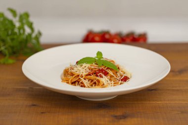 Tabak lezzetli İtalyan spagetti makarna ile taze fesleğen yaprakları, etli, domates sos, sebze ve parmesan peyniri rendesi