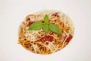 Tabak lezzetli İtalyan spagetti makarna ile taze fesleğen yaprakları, etli, domates sos, sebze ve parmesan peyniri rendesi