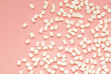 Marshmallow kopya alanı ile pembe arka plan üzerinde. Düz yatıyordu veya en iyi görünümü. Arka plan veya doku renkli mini lokum gibiydi. Kış yiyecek arka plan kavramı.