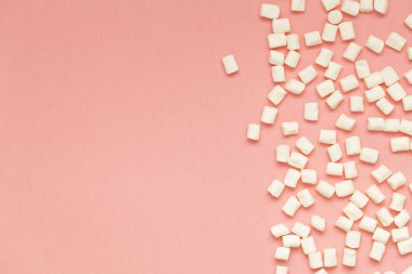 Marshmallow kopya alanı ile pembe arka plan üzerinde. Düz yatıyordu veya en iyi görünümü. Arka plan veya doku renkli mini lokum gibiydi. Kış yiyecek arka plan kavramı.