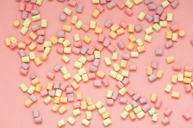 Marshmallow kopya alanı ile pembe arka plan üzerinde. Düz yatıyordu veya en iyi görünümü. Arka plan veya doku renkli mini lokum gibiydi. Kış yiyecek arka plan kavramı.