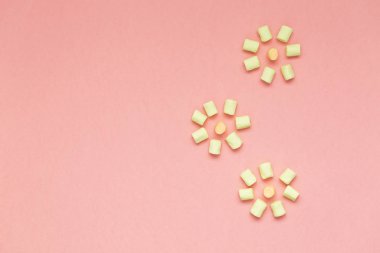 Marshmallow kopya alanı ile pembe arka plan üzerinde. Düz yatıyordu veya en iyi görünümü. Arka plan veya doku renkli mini lokum gibiydi. Kış yiyecek arka plan kavramı.