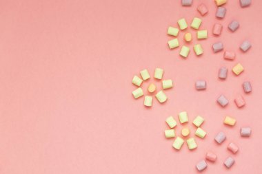 Marshmallow kopya alanı ile pembe arka plan üzerinde. Düz yatıyordu veya en iyi görünümü. Arka plan veya doku renkli mini lokum gibiydi. Kış yiyecek arka plan kavramı.