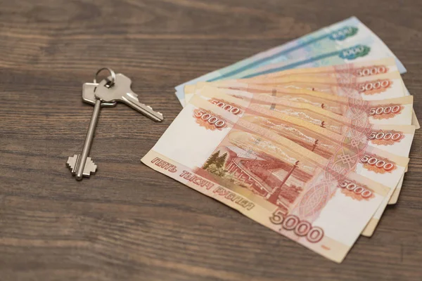 Kiralama ve yeni ev concept - bohça-in para Rus banknot ve evin anahtarları. Finans