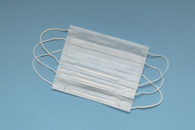 Tıbbi maske mavi arkaplanda izole edildi