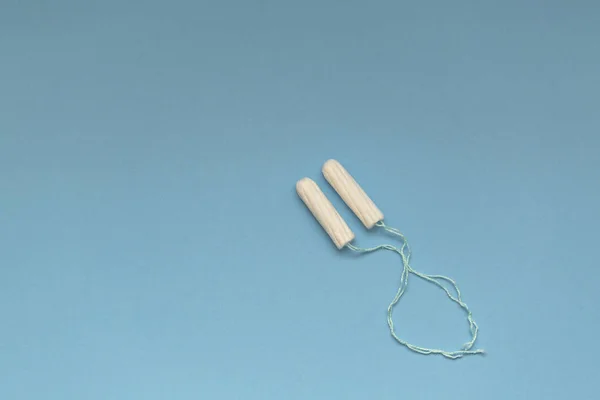 Feminine cotton tampon on blue background