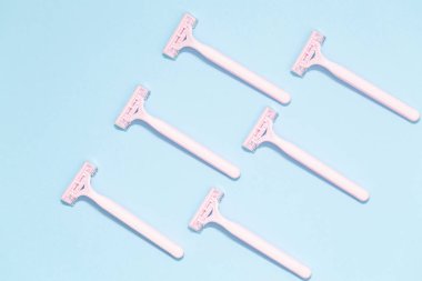 Mavi arka plan üzerinde izole pembe kadın jilet. Mavi arka plan üzerinde jilet kümesi. Kadın disposable jilet pembe. Hijyen cilt vücut bakım kavramı. Epilasyon.
