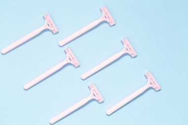 Mavi arka plan üzerinde izole pembe kadın jilet. Mavi arka plan üzerinde jilet kümesi. Kadın disposable jilet pembe. Hijyen cilt vücut bakım kavramı. Epilasyon.