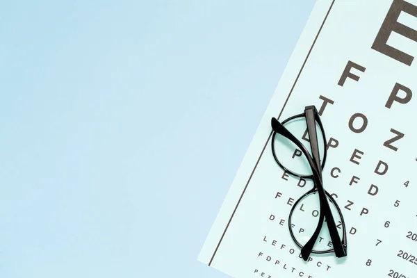 Göz testi, göz muayenesinde. Gözlük göz saydam optik lensler ile mavi arka plan üstten görünüm grafiği test