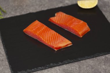 Ham taze lezzetli somon biftek üzerinde siyah arduvaz kaplamak yerleştirilir. Yaban Atlantik balık