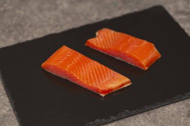 Ham taze lezzetli somon biftek üzerinde siyah arduvaz kaplamak yerleştirilir. Yaban Atlantik balık