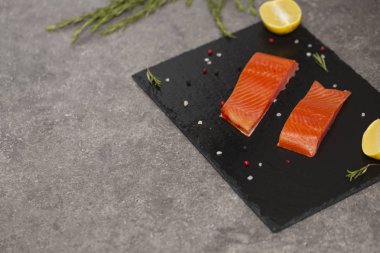 Ham taze lezzetli somon biftek üzerinde siyah arduvaz kaplamak yerleştirilir. Yaban Atlantik balık