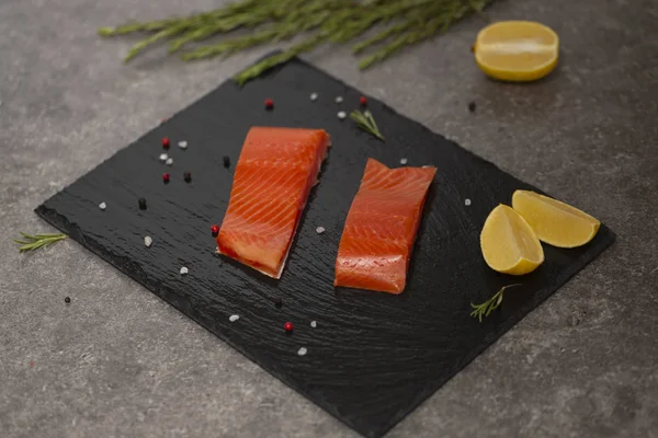 Ham taze lezzetli somon biftek üzerinde siyah arduvaz kaplamak yerleştirilir. Yaban Atlantik balık