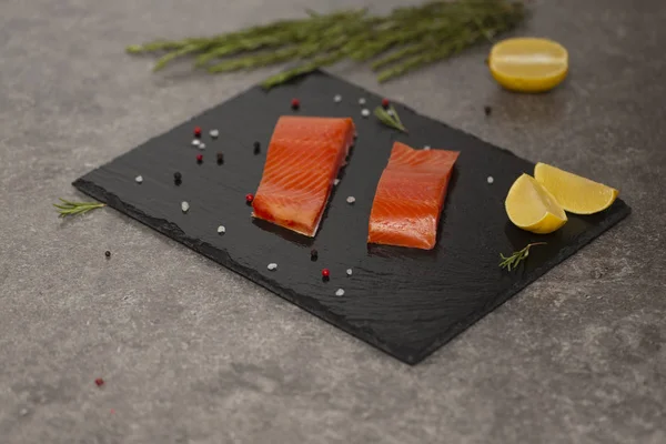 Ham taze lezzetli somon biftek üzerinde siyah arduvaz kaplamak yerleştirilir. Yaban Atlantik balık