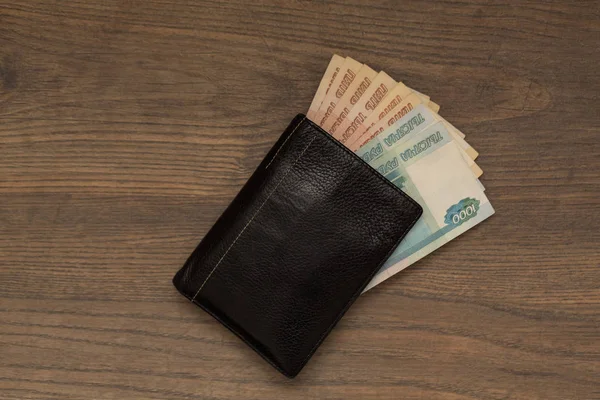 Cash in wallet on wooden background, russians money, finance concept