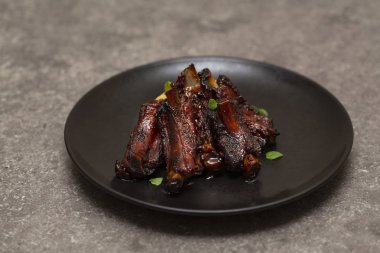 Siyah bir tabak patates püresi ile domuz kaburga ızgara