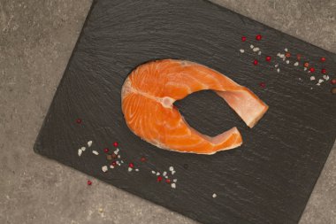 Siyah arduvaz tabakta taze çiğ somon kırmızı balık biftek