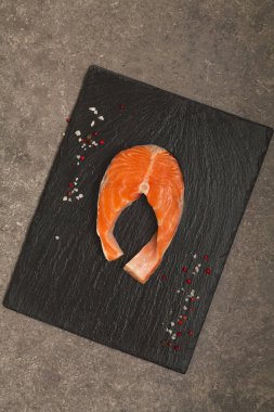 Siyah arduvaz tabakta taze çiğ somon kırmızı balık biftek