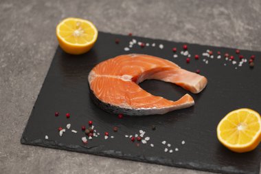 Baharatlar ve limon siyah arduvaz tabakta taze somon biftek