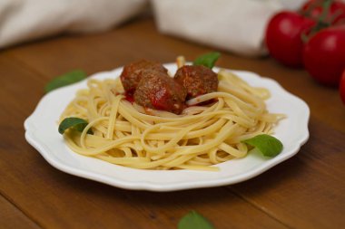 Spagetti makarna köfte domates sosu, fesleğen, ahşap arka plan üzerinde otlar parmesan peyniri ile. Seçici odak