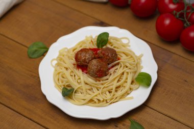 Spagetti makarna köfte domates sosu, fesleğen, ahşap arka plan üzerinde otlar parmesan peyniri ile. Seçici odak