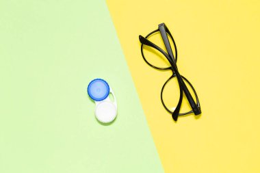 Kontakt lens ve gözlük renk arka plan üzerinde düz yatıyordu kompozisyonu