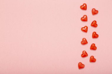 Aşk, kopya alanı en az tarzı, tebrik kartı şablonu pastel pembe zemin üzerine kırmızı kalplerin üstten görünüm kavramı. Düz yatıyordu.