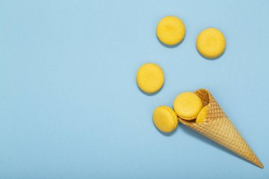 Gözleme koni ile renkli macaron veya mavi pastel renkli üstten görünüm üzerinde acıbadem kurabiyesi. Düz yatıyordu kompozisyon.