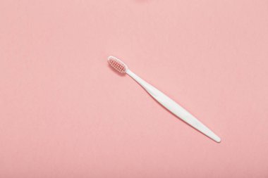 Pembe bir arka plan üzerinde diş fırçası.